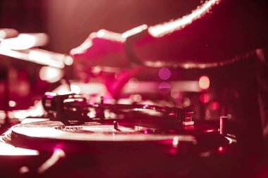 Kiev-4 Temmuz, 2018: Dj gece kulübü sahnede retro Technics Sl 1210 pikap ile müzik çalar. Rave partisi DJ parlak kırmızı ışıklar sahnede müzik seti oynamak