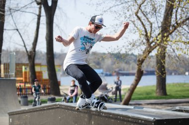 Kiev - 15 Nisan, 2018: agresif satır içi skate Yarışması açık skatepark içinde. Genç kaykaycı çocuk demiryolu üzerinde rulman ağızları ile biler..