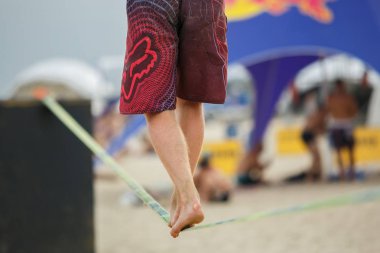 Odessa, Ukrayna-21 Haziran, Walker sahilde slackline yarışmasında halat üzerinde 2017:Feet. Sportif gençler bolluk doğrultusunda rekabet tightropes sahil üzerinde yürürken yürüyüş katılmak