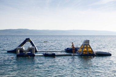 Brela, Hırvatistan - 26 Haziran, 2017: bouncing Kalesi ve su Sal beach eğlence için Infltable. Yaz tatili için güzel seyahat hedef. Popüler turistik aktivite, su spor arka plan