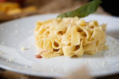İtalyan makarna tabağı ve kekik yaprakları beyaz tabakta eritilmiş parmesan peyniri ile servis ediliyor. Restoranda nefis İtalyan mutfağı. Lezzetli ve doğal yemek.
