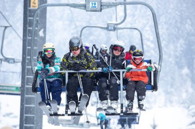 Bukovel, Ukrayna - 19 Mart, 2018: sandalye Asansör kayakçı ve Snowboard düşkünleri kış tatil için. Etkin turistler üzerinde snowboard binmek için Asansör ve kayaklar Bukovel Winter Park Karpat Dağları