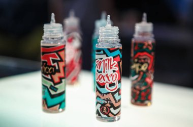 Kiev, Ukrayna-14 Nisan, 2018: yeni lezzetli vape suyu sigara elektronik vaping cihazlar ile için. Sigara içenler vape Expo Satılık. Plastik şişe kapları ile ejuice gliserin sıvı vaper mağaza