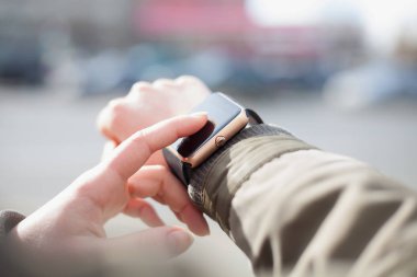 Şık akıllı saatini kullanan bir kız elleri. Bu yeni becerikli alet her zaman internet ve sosyal medya ağları ile istediğiniz yerden bağlı kalmak sağlar.