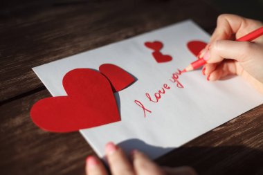 Kızın aşk mektubu Saint Sevgililer Day.Handmade kartpostalda rakam şeklinde kırmızı kalp ile Kraft kağıt kesti. Kadın kart 14 Şubat tatil kutlaması için yazmak 