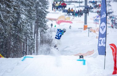 Bukovel, Ukrayna-19 Mart, 2018: Genç snowboard atlet rampa Kayak Park Bukovel kış kar tahtada yapmak hava hüner Park.Sportsman yarışmada doğa kış sporları sırasında atlar