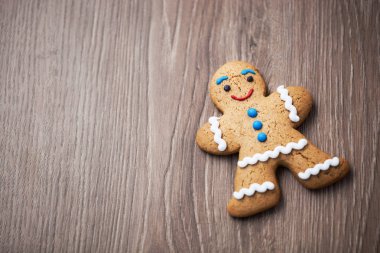 Komik gülümseyen zencefilli kurabiye adam ahşap masa üzerinde. İyi tadı ile gülümseyen yenilebilir karakter. Makro, koyu kahverengi ahşap üzerine kopya alanı kapatın