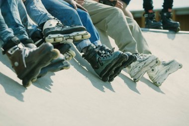 Açık skate Park beton rampa tepesinde duran agresif inline paten giymiş rollerbladers metrelik. Silindir bıçakları için hile ve biler giyen aşırı spor atlet