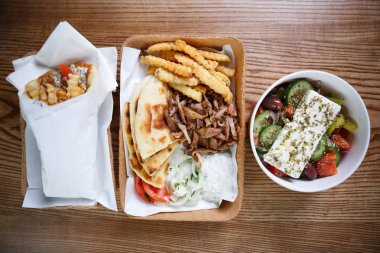 Traiditional Yunan fast food menü kızarmış et souvlaki ve kavrulmuş gyros çanak ile genel gider bir kadeh. Sağlıklı taze Yunan salatası kağıt tabak içinde servis. Fast food Restoran götürün