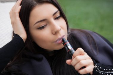 Popüler modern Buharlaştırıcı aygıt ile çekici genç kız vaping. Nikotin, vape meyve gliserin e-sıvı veya e-suyu içmeyin. Güvenli ve sağlıklı sigara alternatif