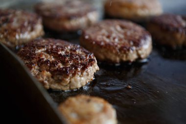 Hamburger kafe mutfakta yemek. Taze parça üzerinde tava kavurma et. Amerikan fastfood aşçılık. Büyük şişman bir parça et Fry yağda. Yemek, yüksek kolesterol seviyesi gıda Unhelathy