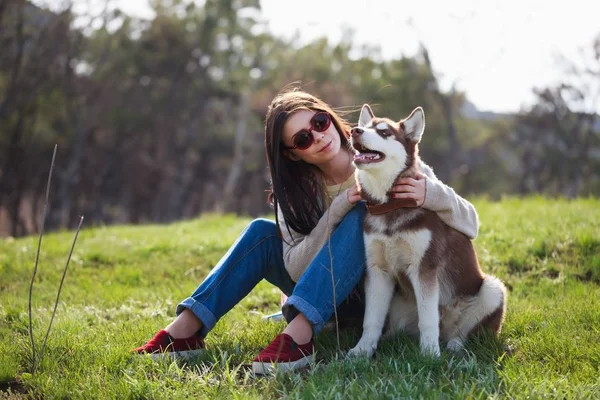 Sorrindo Jovem Morena Sentada Com Seu Cão Husky Parque Verde — Fotografia de Stock