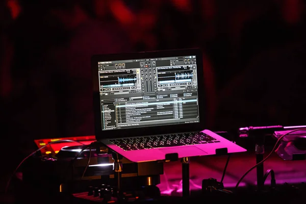 キエフ 2018 ナイトクラブのパーティーで のラップトップで音楽を再生するためのソフトウェア プログラムを混合プロのオーディオを追跡します クラブでのコンサートのステージ上でディスク ジョッキー アップルの Macbook ノートブック — ストック写真