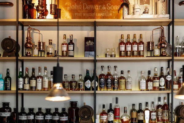 Moskova-26 Mart 2017: Dewars Bar iç mekan. Güçlü likör raflarda şişeler içiyor. Yetişkin eğlence arka plan. Işıklı pub iç, viski şişe raf odaklanmak