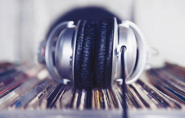 Audiophile headphones on analog vinyl records collection. DJ head phones. Play music, listen to tracks in silver headset. Close up,macro