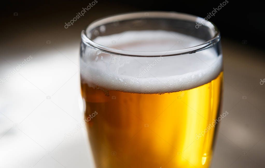 Glass of fresh brewed craft lager beer.High mug of ale light beer with foam bubles in crystlal clear glass dishware.Every pub main alcoholic drink for adults