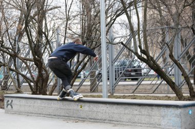 Moskova - 25 Mart, 2017: genç agresif Inline patenci adam eziyet çıkıntının üzerinde aşırı hatlı tekerlekli paten açık skate park sokak skate Yarışması sırasında demiryolu ile