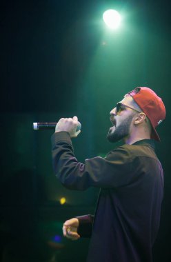 Moskova - 20 Ekim, 2016: Rap şarkıcı şarkı sahne gece kulübü. Hip hop müzik sanatçı şarkı mikrofon sahnede. Rapçi parlak konser aydınlatma.