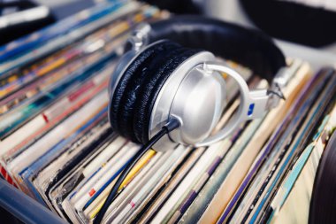 DJ kulaklık vinil kayıt üzerinde. DJ, ses meraklısı, müzik aşığı için analog kayıtlar ve koca kafa telefonlarının toplama.