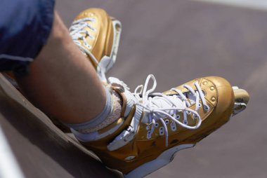 satır içi skater skatepark mekanlarda profesyonel agresif paten giymiş bacaklar. bir rampa üzerinde oturan