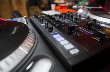 Pikap dj vinil plak çalar ve ses denetleyicisi karıştırma. Analog ve dijital ses teknolojisi Dj müzik çalmak için. Yakın, makroyu profesyonel stüdyo, konser, olay için disk jokey donatımın ayarlama