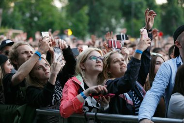 Moskova-21 Temmuz 2017: Açık Hava Festivali sırasında genç insanların büyük konser izleyici Gazgolder Live. heyecanlı genç kız güvenlik çit arkasında konser Mobil fotoğraf çekmek