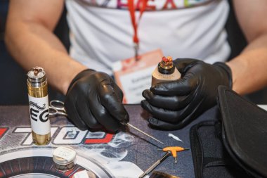 Kiev, Ukrayna-14 Nisan, 2018: Titanyum tel ve Vape Expo dükkanda vaping cihazı ile gliserin sıvı sigara için fitil değiştirme uzmanı. Profesyonel tamir elektronik sigara Gadget'ta teller