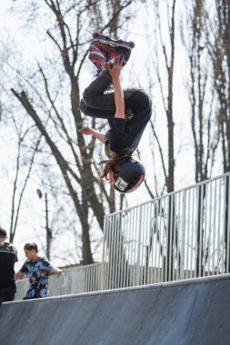 Kiev-15 Nisan, 2018: Agresif satır içi skate Yarışması açık skatepark içinde. Genç kaykaycı çocuk backflip rulman ağızları giyiyor büyük rampa üzerinde gerçekleştirir. Serin aşırı gençlik spor yarışması