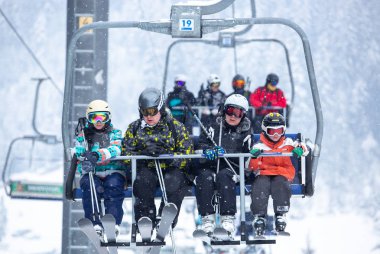 Bukovel, Ukrayna - 19 Mart, 2018: sandalye Asansör kayakçı ve Snowboard düşkünleri kış tatil için. Etkin turistler üzerinde snowboard binmek için Asansör ve kayaklar Bukovel Winter Park Karpat Dağları