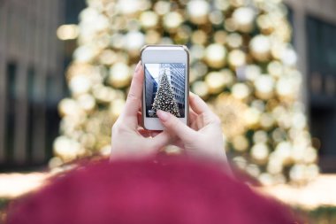 Noel ağacı açık havada genç esmer kız poz, açık renklerle dekore edilmiş