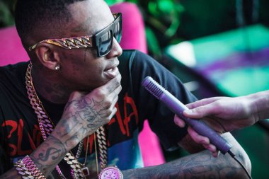 Moskova - 27 Mart, 2015: popüler Amerikalı rap şarkıcısı Soulja boy röportaj. Mikrofon adamı görüşmelerde şık siyah dövme.