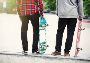 Beton skate Park açık havada bir rampa üzerinde duran iki patenci çocuklar. Kullanılan modele Holding eski paten boardsm hile yapmak için hazır. 