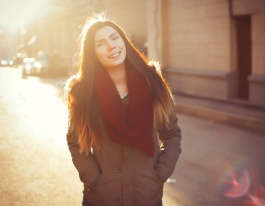 Genç hipster Fularlı Kız açık havada parlak gün poz gri parka ceket ve trendy marsala. Hava harika, güneşin parlak olduğunu ve güzel bir modeldir