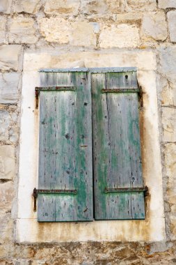 Ahşap panjurlarla eski ev penceresi. Geleneksel Hırvat mimarisi.