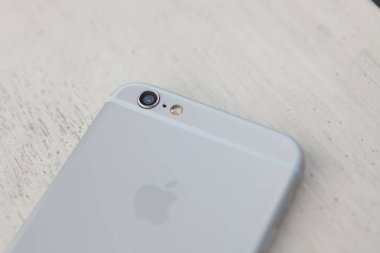 Ahşap yüzey üstünde hareket eden telefon. Modern smartphone modeli, büyük gümüş dava. 