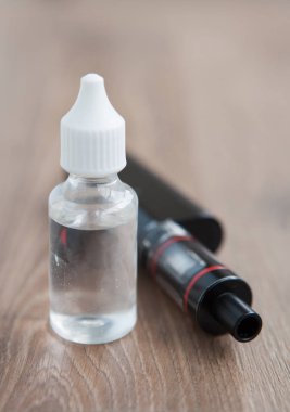 Modern vaping aygıt ve dosyalama e-suyu sıvı. Sıvı tütün probilen glicol ve gliserin temel ile tekrar doldur. Metin üzerinde şeffaf şişe yerleştirin.