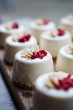 Raspberrie tepesi ile birçok taze pişmiş İtalyan cupcakes pasta cafe menüsünde ahşap plaka servis. Restoran gıda dikey arka plan