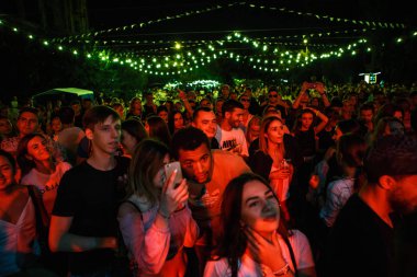 Kiev-11 Temmuz, 2018: Grup genç insan Yaz Festivali Bazar açık müzik dinlemek. Eğlence olay kalabalıkta kırmızı ışıklar