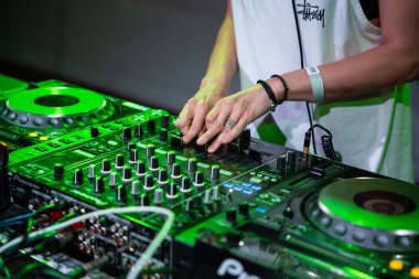 Kiev-11 Temmuz 2018: Sahne alanı üzerinde parça karıştırma dj kız elinde konser. Profesyonel DJ ses donanımı üzerinde yeşil ışıklar sahnede. DJ müzik oynayan Bayan Yaz Festivali olayda gece ayarla.