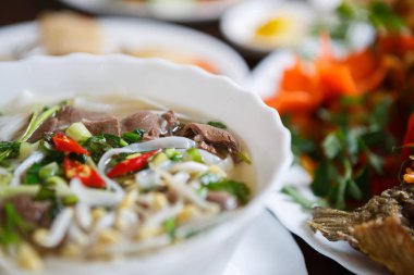 Lezzetli Vietnam geleneği restoran yemek pho bo çorba. Doğal egzotik yemek menüsü. Kase lezzetli Asya sıcak yemek sığır eti ve erişte ile hizmet