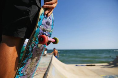 Odessa, Ukrayna-21 Ağustos, 2017: Skater boy tutar eski kaykay elinde açık skatepark içinde mini rampa üzerinde. Aşırı yaz spor rekabet arka plan. Popüler gençlik spor