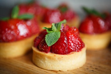 Nane yaprakları ve taze çilek ile deicious çilek cupcakes Tepesi üzerinde bisküvi tabanı üzerinde yemek. Cupcake Cafe tatlıya görüntüsünü kapatın. İtalyan tatlı gıda makro