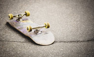 Asfalt üzerinde eski kaykay güverte. Popüler doğa sporları arka plan. Paten kurulu eğlenmek için binmek