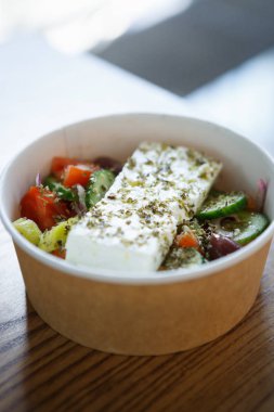 Doğal diyet taze sebze Yunan salatası yemek. Sağlıklı beslenme için geleneksel Yunanistan mutfağı. Sebze ve kağıt tabak içinde servis zeytinyağı sosu üzerine kapatın. Sağlıklı düşük yağlı fast food