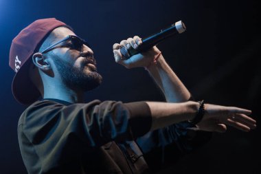 Moskova - 20 Ekim, 2016: Rap şarkıcı şarkı sahne gece kulübü. Hip hop müzik sanatçı şarkı mikrofon sahnede. Rapçi parlak konser aydınlatma.