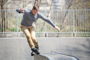 Kiev - 15 Nisan, 2018: agresif satır içi skate Yarışması açık skatepark içinde. Genç kaykaycı çocuk demiryolu üzerinde rulman ağızları ile biler..