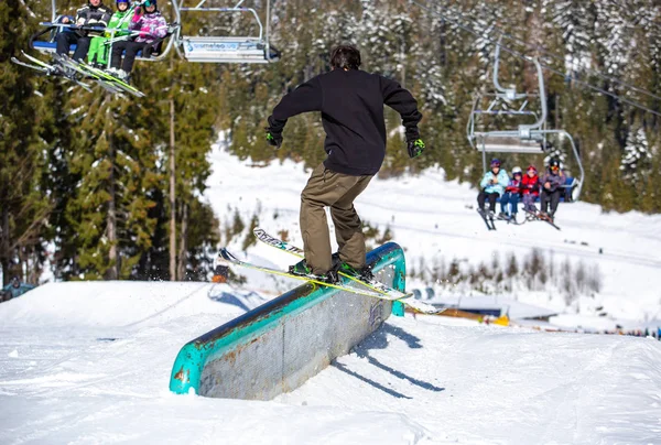 2018年3月19日 年轻的免费滑雪骑手在 Bukovel 冬园的铁轨上磨合 在阳光明媚的阳光明媚的日子里 Freeski 运动员在极限运动比赛中在管道上磨合 — 图库照片