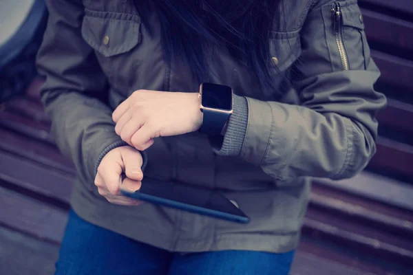 Hipster Menina Casaco Parka Olhando Para Seu Relógio Inteligente Segurando — Fotografia de Stock