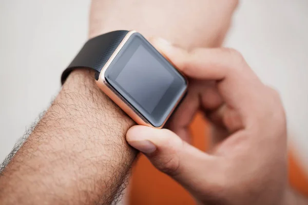 Hands of african black boy using his trendy smart watch.Modern gadget that lets you always stay connected to internet,social media from everyware.Macro close up on wrist watches.