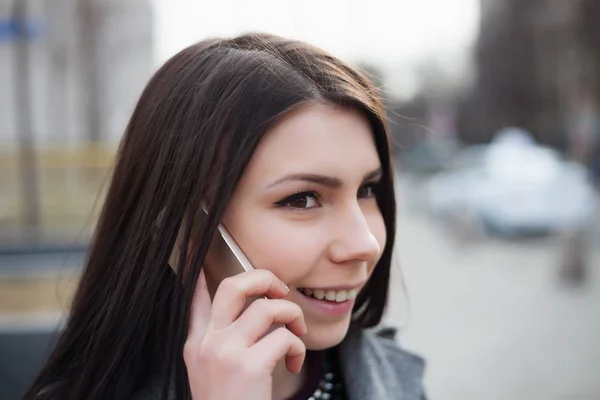 年轻女人谈电话以友好的微笑 — 图库照片